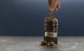 Hand puts coins in piggy bank on black background, growth of savings. Economic crisis and saving money. Donation to charity fund