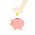Hand is putting coins in a piggy bank. Royalty Free Stock Photo