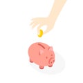 Hand is putting coins in a piggy bank. Royalty Free Stock Photo