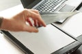A hand puts a piece of paper closing a flatbed scanner with a laptop computer in the background. Selective focus and motion blur i Royalty Free Stock Photo
