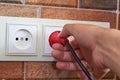 Hand puts plug in the socket,man`s hand inserts a plug into an outlet in the kitchen Royalty Free Stock Photo