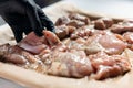 hand puts raw chicken fillet meat on pan before cooking in oven at home