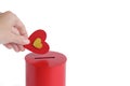 hand puts Red heart into slot of red donation box. Concept of donorship, life saving or charity. Royalty Free Stock Photo