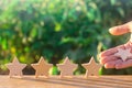 Hand puts / removes the fifth wooden star. Get the fifth star. The concept of the rating of hotels and restaurants, the evaluation