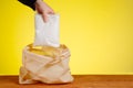 A hand puts sugar in a shopping bag. The concept of purchasing and delivering products