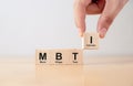 Hand puts wooden cubes with MBTI, Myers-Briggs Type Indicator on table Royalty Free Stock Photo