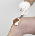 Hand putting Adhesive Bandage on knee. Royalty Free Stock Photo