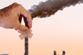 hand putting a band aid on a smoke stack Royalty Free Stock Photo
