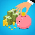 Hand putting bitcoin dollar into saving piggy bank