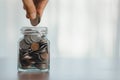 Hand putting coin in glass jar for save money for prepare in the future Royalty Free Stock Photo