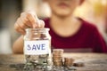 Hand putting coin in a jar collect money saving for life,future,education on wooden table. Save Money concept