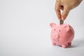 Hand Putting Coin Into Piggy Bank