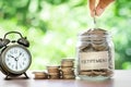 Hand putting Coins in glass jar Royalty Free Stock Photo