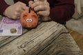 Man putting coins in piggy bank at home