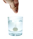 Hand putting effervescent pill into glass