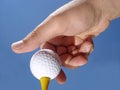 Hand Putting Golf Ball on Tee