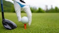 Hand putting golf ball on tee in golf course Royalty Free Stock Photo
