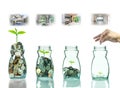 Hand putting mix coins and seed in clear bottle with step of construction house Royalty Free Stock Photo