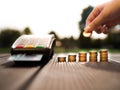 Hand putting money coins stack growing and credit cards swipe through terminal on nature background Royalty Free Stock Photo