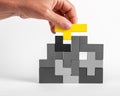 Hand putting outstanding yellow element in tetris puzzle. Formation concept. Creative unique idea. Logical game for