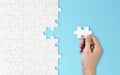 Hand putting a piece of white jigsaw puzzle. Pattern texture separated in strategy and solution of team business success Royalty Free Stock Photo