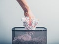 Hand putting shredded paper in basket Royalty Free Stock Photo