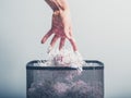 Hand putting shredded paper in basket Royalty Free Stock Photo