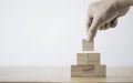 Hand putting and stacking blank wooden cubes on table with copy space for input wording and infographic icon Royalty Free Stock Photo