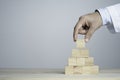 Hand putting and stacking blank wooden cubes on table with copy space for input wording and infographic icon Royalty Free Stock Photo