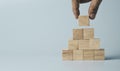 Hand putting and stacking blank wooden cubes on table with copy space for input wording and infographic icon Royalty Free Stock Photo