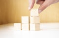 Hand putting and stacking blank wooden cubes on table with copy space for input wording and infographic icon Royalty Free Stock Photo