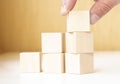 Hand putting and stacking blank wooden cubes on table with copy space for input wording and infographic icon Royalty Free Stock Photo