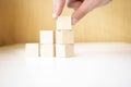 Hand putting and stacking blank wooden cubes on table with copy space for input wording and infographic icon Royalty Free Stock Photo