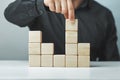 Hand putting and stacking blank wooden cubes on table with copy space for input wording or infographic icon