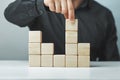 Hand putting and stacking blank wooden cubes on table with copy space for input wording or infographic icon Royalty Free Stock Photo