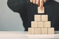 Hand putting and stacking blank wooden cubes on table with copy space for input wording or infographic icon Royalty Free Stock Photo