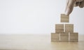 Hand putting and stacking blank wooden cubes on table with copy space for input wording and infographic icon Royalty Free Stock Photo