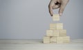 Hand putting and stacking blank wooden cubes on table with copy space for input wording and infographic icon Royalty Free Stock Photo