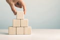 Hand putting and stacking blank wooden cubes on table with copy space for input wording or infographic icon