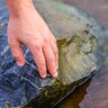 Hand putting stone on stacking stones on the riverside. The stones are stacked on the river side. Royalty Free Stock Photo
