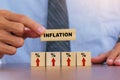 Hand putting wooden cube and inflation word.Idea for FED consider interest rate hike, world economics, and inflation control, US Royalty Free Stock Photo