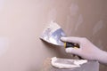 Hand with putty knife repair wall, Hand with a spatula, spatula with spackle paste structure, process of applying layer of putty Royalty Free Stock Photo
