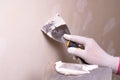 Hand with putty knife repair wall, Hand with a spatula, spatula with spackle paste structure, process of applying layer of putty Royalty Free Stock Photo