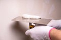 Hand with putty knife repair wall, Hand with a spatula, spatula with spackle paste structure, process of applying layer of putty Royalty Free Stock Photo