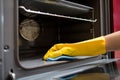 Hand with rag cleaning oven at home kitchen Royalty Free Stock Photo