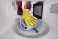 Hand with rag closeup inside the microwave Royalty Free Stock Photo