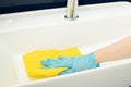 Hand with a rag washes the sink in the bathroom, professional cleaning service Royalty Free Stock Photo