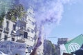 Hand raising a purple smoke flare in the air during the 8M women strike