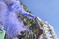 Hand raising a purple smoke flare in the air during the 8M women strike