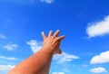 Hand reach out so it the on blue sky background Royalty Free Stock Photo